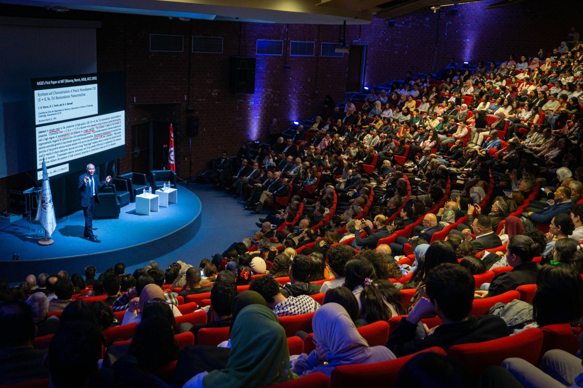 A speaker presenting to a full auditorium