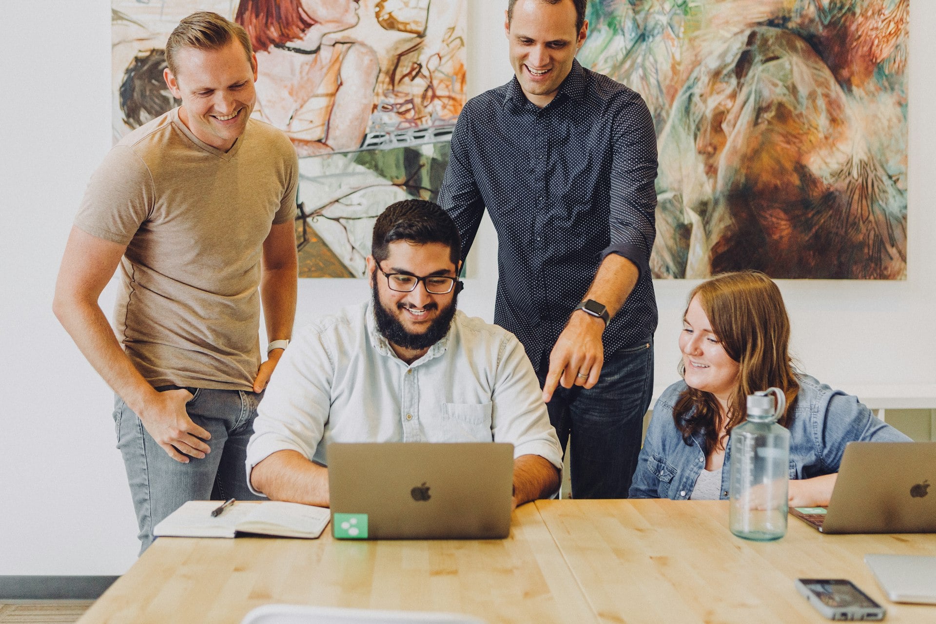 A small team gathered around a laptop